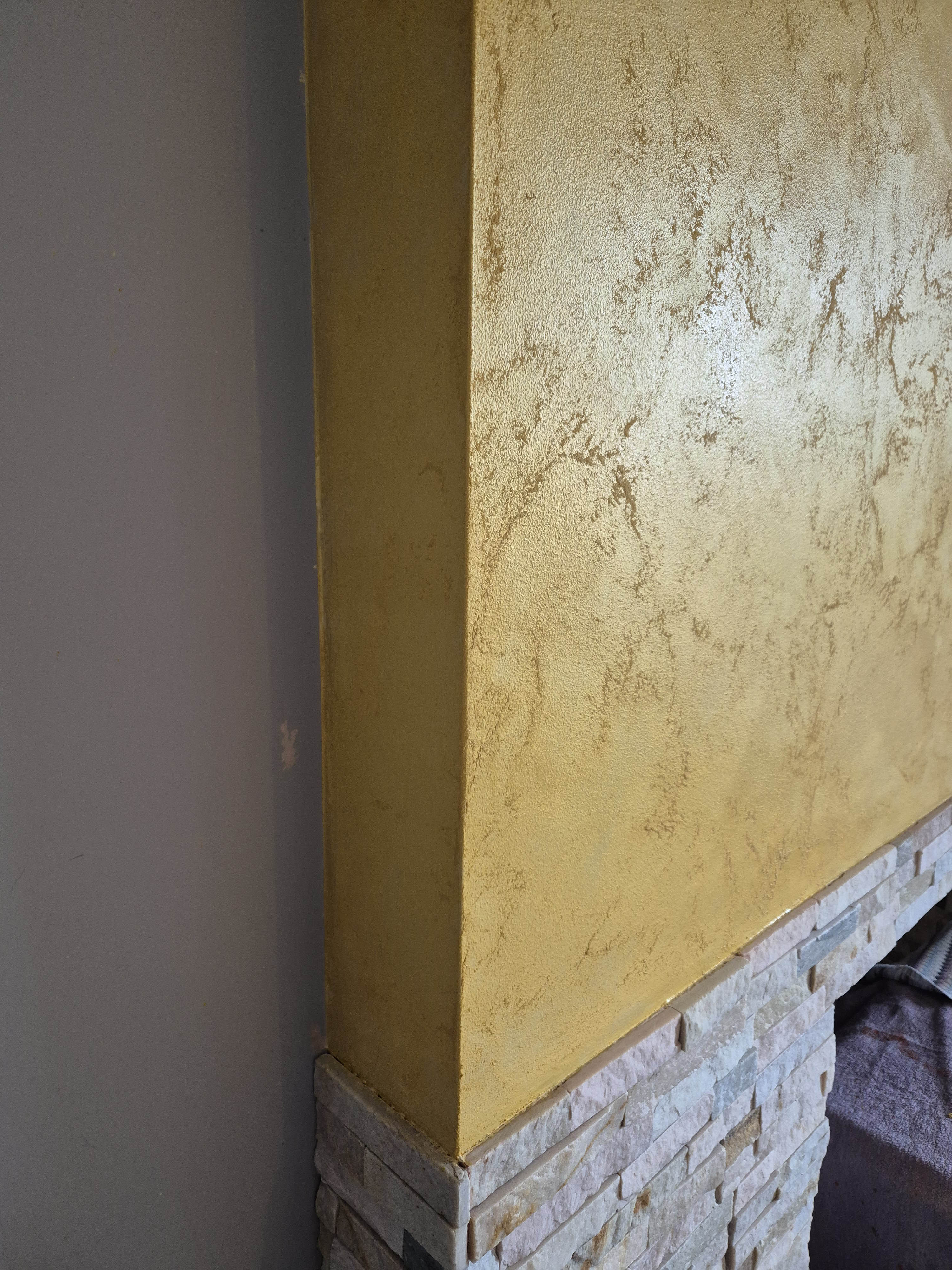Gold metallic polished plaster above fireplace surround in Inverness